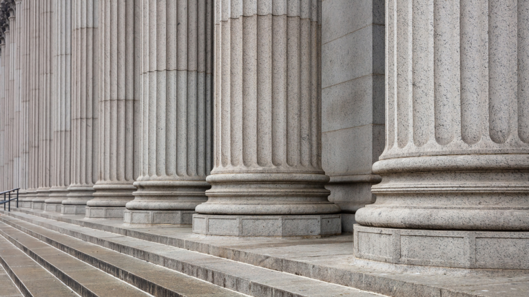 Angled shot of roman style columns outside of a government building